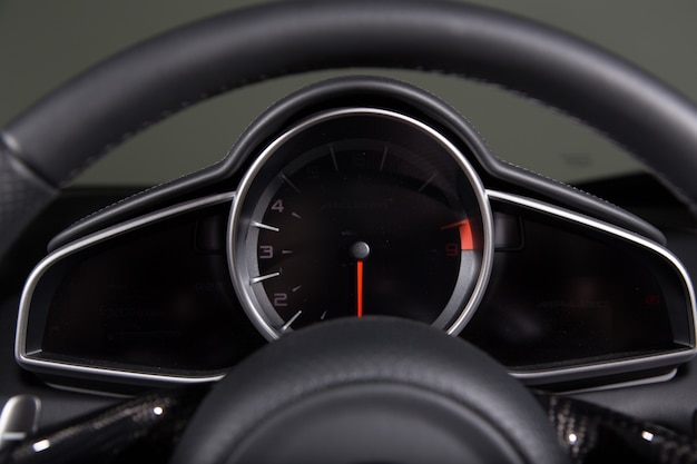 Free photo closeup of a speedometer and a steering wheel of a modern car under the lights