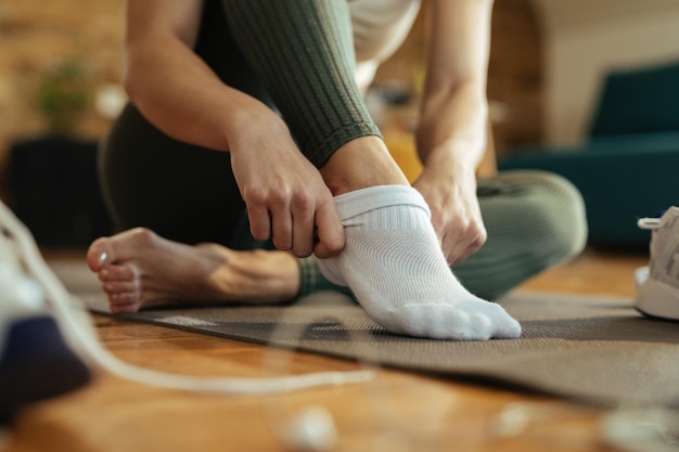 Free photo closeup of sportswoman wearing white socks while preparing for workout at home