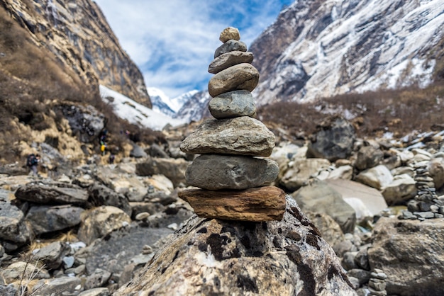 Closeup of stones on top of each other surrounded by rocks covered in the snow under the sunlight