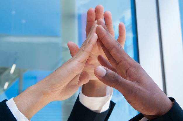 Free photo closeup of three business people high fiving outdoors