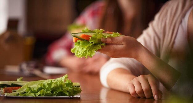 Closeup toned picture of vegetarian dish represented in someones hand Lady sitting in vegetarian cafe or restaurant