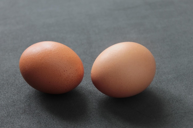 Closeup of two raw eggs on a gray table