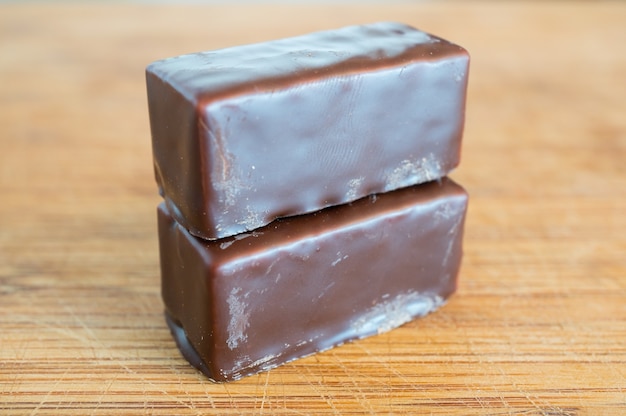 Free photo closeup of two stacked chocolate blocks on a wooden table