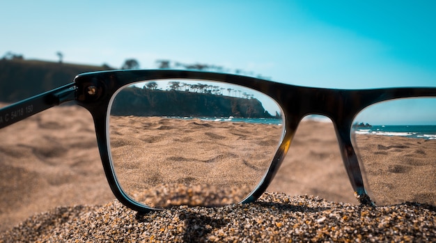 Free photo closeup view of beach viewed from the lenses of black glasses