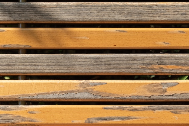 Closeup view of the bench with partly chipped paint on the planks