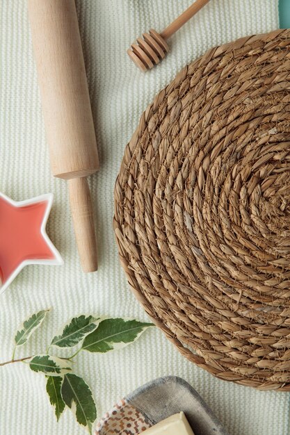 Closeup view of trivet for hot dishes and rolling pin with jam butter leaves on white background