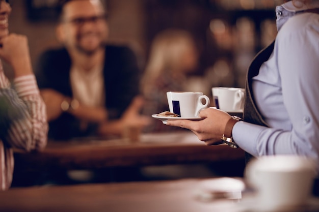 Closeup of waitress carrying coffee cups while working in a cafe