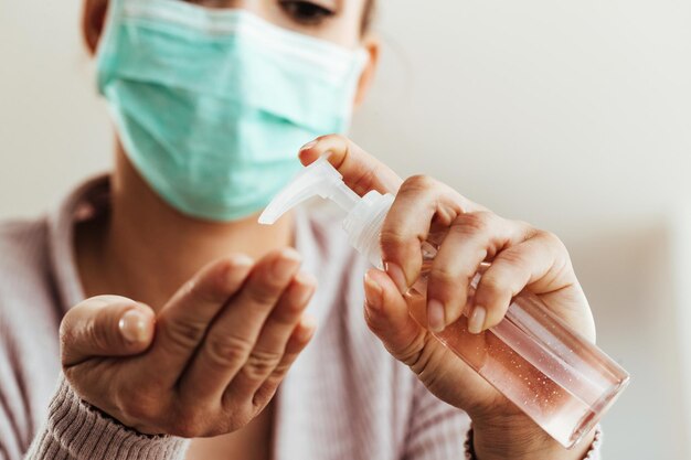 Closeup of woman cleaning her hands with antiseptic hand gel