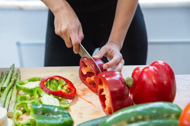 Free photo closeup of woman cutting fresh sweet pepper