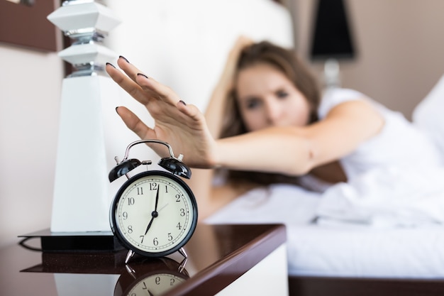 Free photo closeup on woman hand reaching to turn off alarm clock in the morning