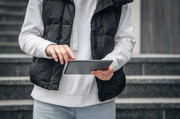 Closeup a woman is using a tablet outside