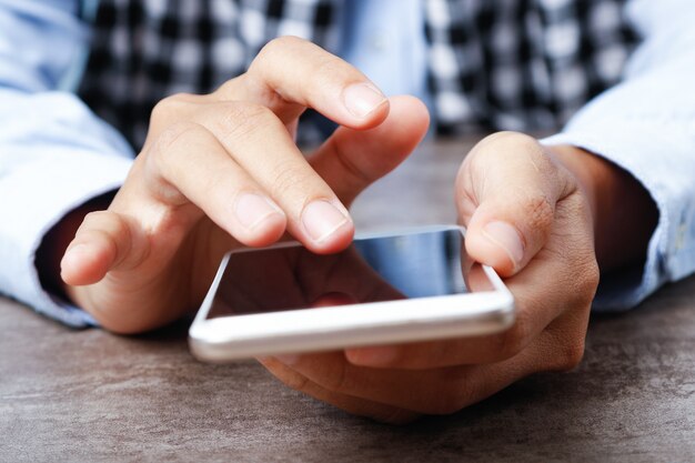 Closeup of woman using smartphone at table