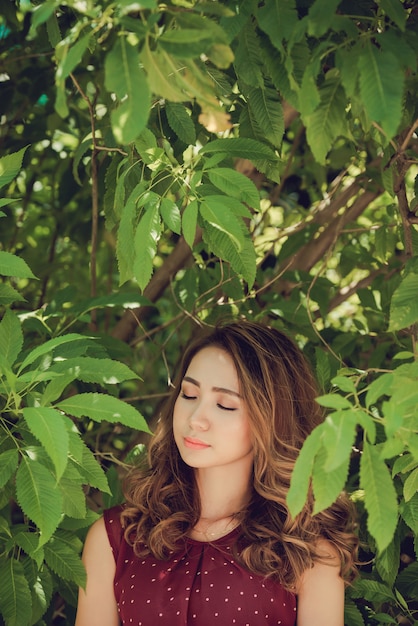 Free photo closeup of woman in the woods enjoying nature with eyes closed