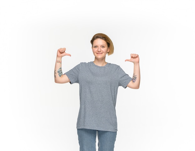 Closeup of young woman's body in empty gray t-shirt isolated on white background. 