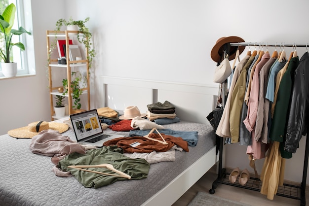 Clothes and laptop on bed high angle