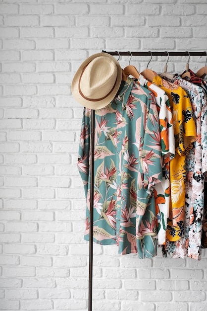 Free Photo clothing rack with hawaiian shirts with floral print and hat