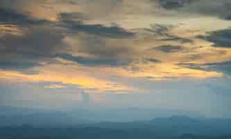 Free photo clouds at sunset over mountains