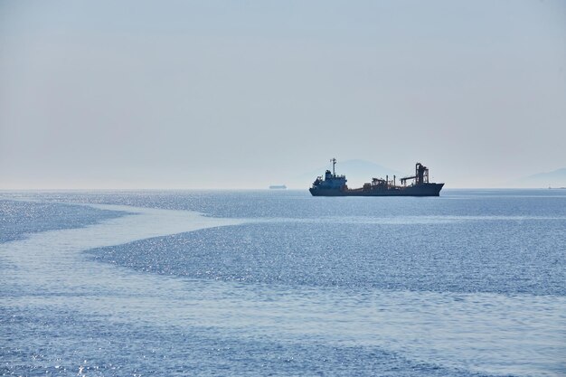 Cloudy horizon and Fog over the sea waves natural background cargo ship on the horizon