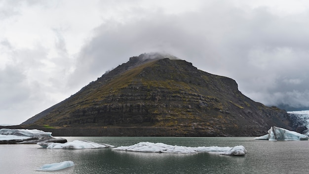 Free photo cloudy nature landscape by lake