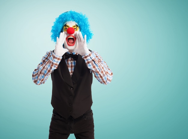 Free photo clown screaming with hands in mouth