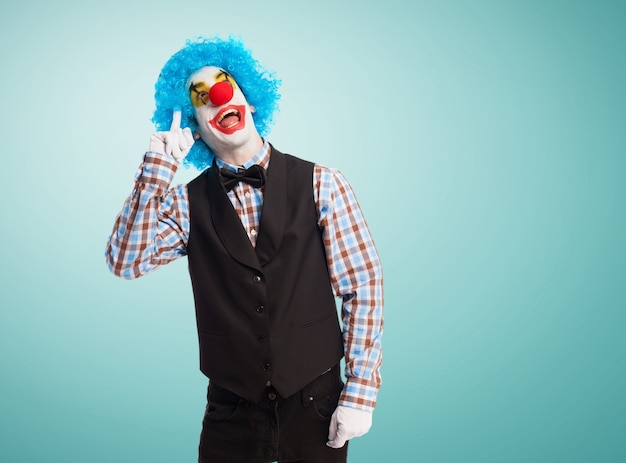 Free photo clown with finger on forehead and smiling