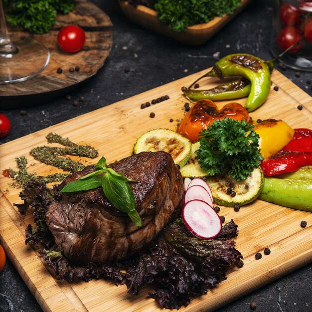 Club Beef steak with pepper sauce and Grilled vegetables on cutting board