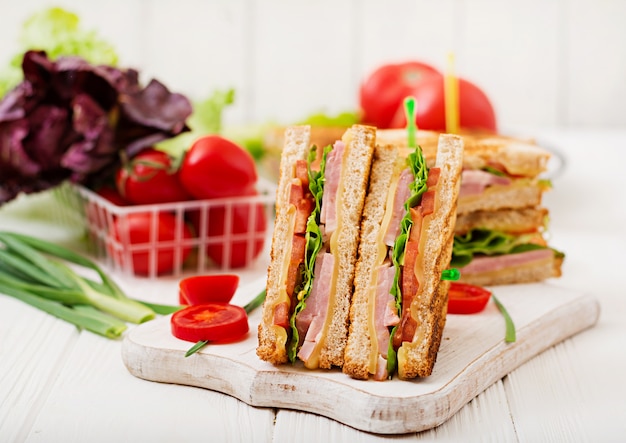 Club sandwich - panini with ham, cheese, tomato and herbs. Top view