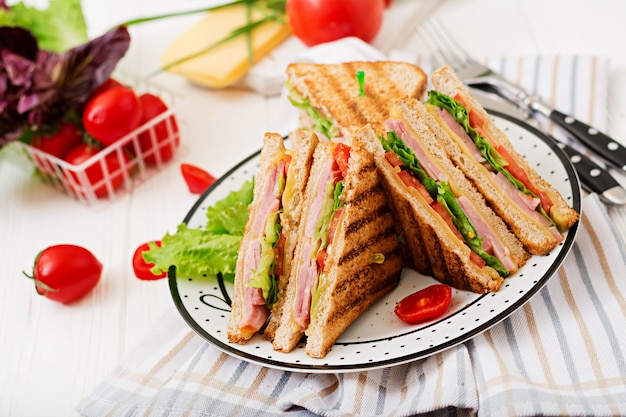 Club sandwich - panini with ham, cheese, tomato and herbs.