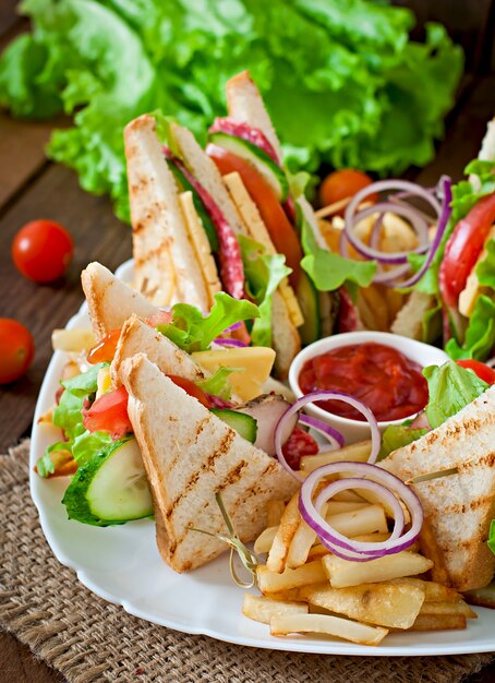 Club sandwich with cheese, cucumber, tomato, smoked meat and salami. Served with French fries.