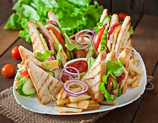 Club sandwich with cheese, cucumber, tomato, smoked meat and salami. Served with French fries.