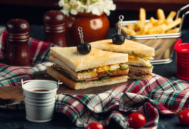 Free Photo club sandwich with eggs, lettuce, salami, cucumber, tomato, served with fries