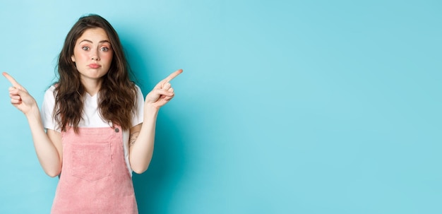 Free Photo clueless and confused cute timid girl shrugging unaware pointing fingers sideways at two sides with