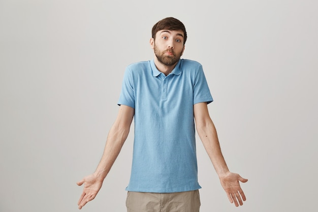 Clueless funny young bearded man posing