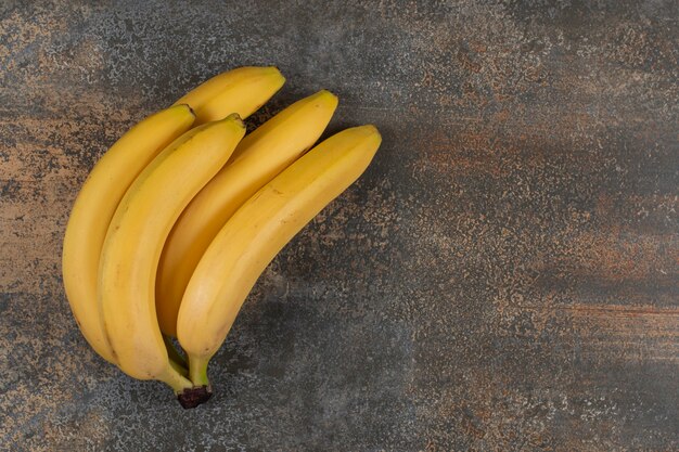 Cluster of ripe bananas on marble table. 