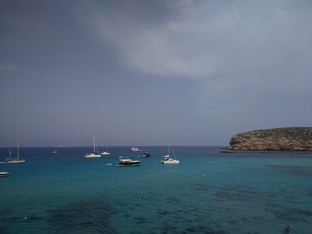 Coast next to Ibiza with a couple of boats before the stormy weather