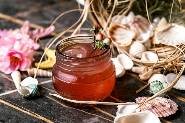 Cocktail in jar placed around seashells and starfish