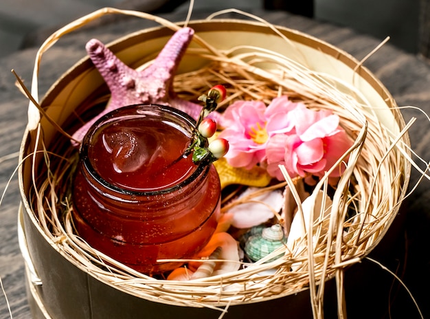 Cocktail in jar placed in box with seashells and starfish