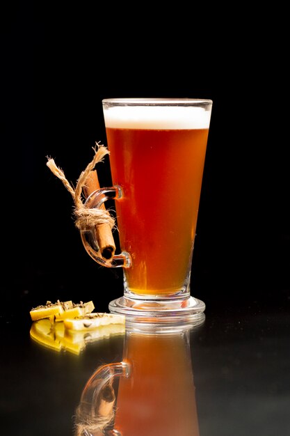 Cocktail with cinnamon stick and lemon slices on the table