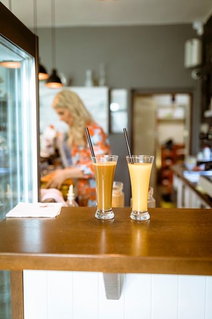 Cocktails on bar with waitress in background