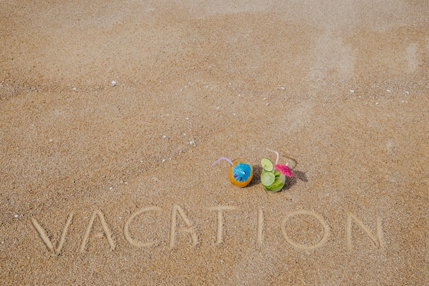 Free photo cocktails and message on sand