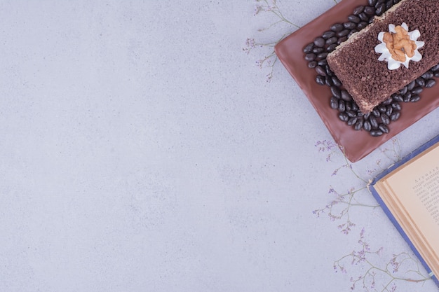 Free photo cocoa cake slice with walnut with coffee beans.