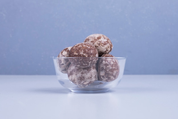 Cocoa gingerbreads in a glass cup on blue in the center.