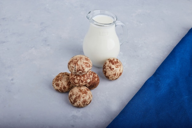 Cocoa gingerbreads isolated on grey background with a jar of milk. 