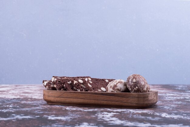 Cocoa gingerbreads in a wooden plate on blue.