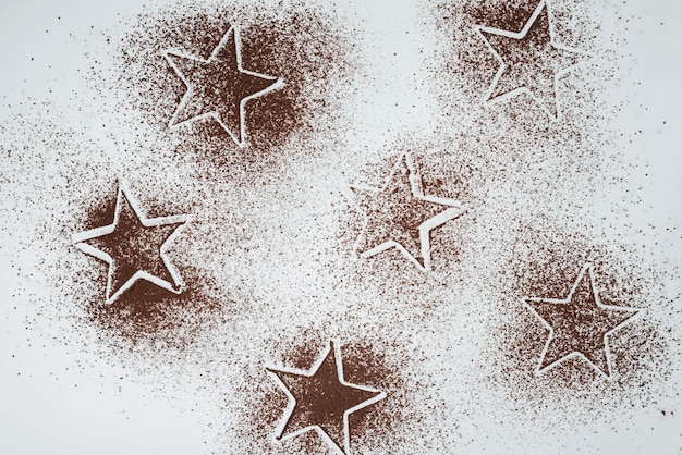 Free photo cocoa powder star shapes on white background