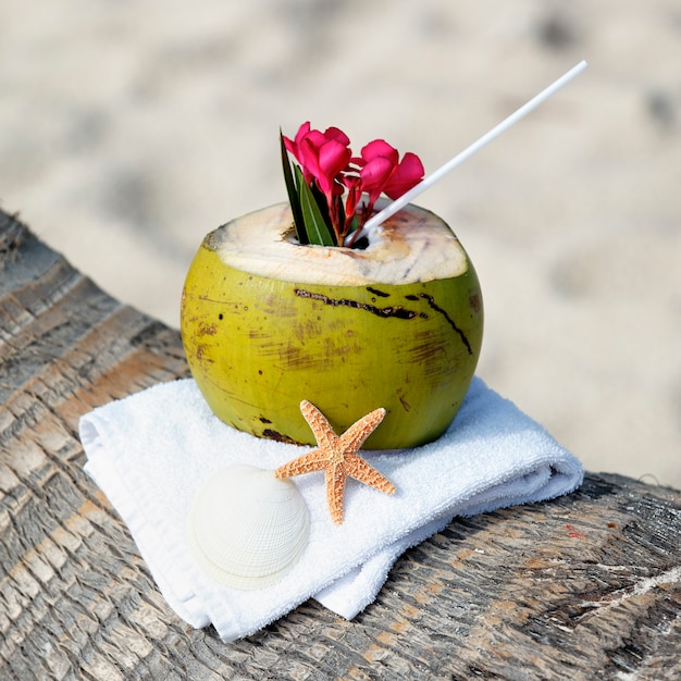 Free Photo coconut cocktail with drinking straw on a palm tree in the beach