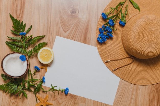 Free photo coconut, leaves, hat, white paper and lemmon