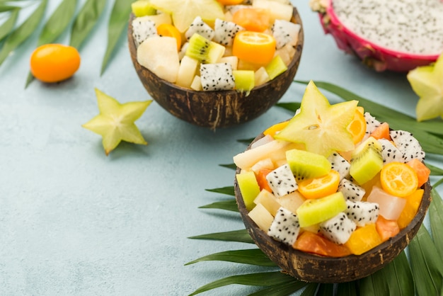 Free photo coconuts filled with fruit salad and yogurt