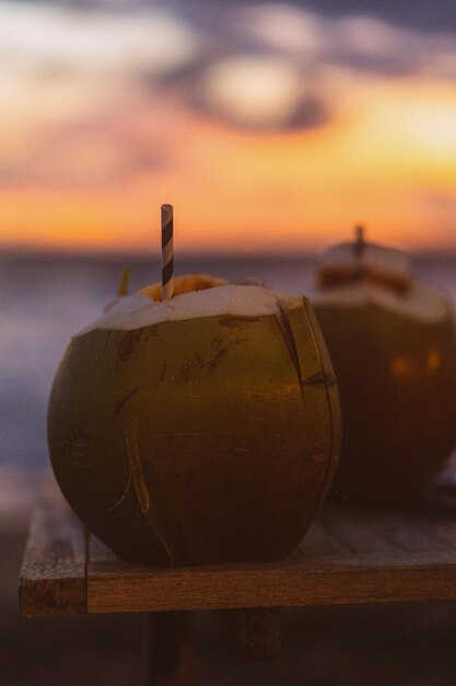 Coconuts with a straw on sunset background, tropical life