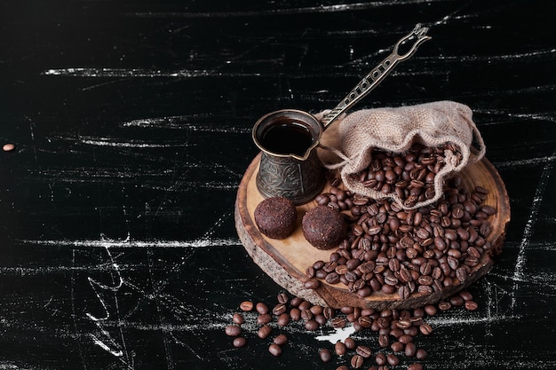 Free photo coffee beans on black background with pralines.